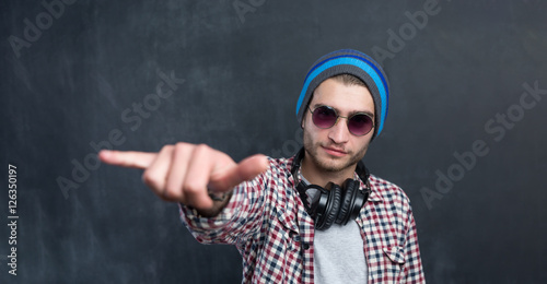 Handsome DJ posing in studio on dark background with headphones