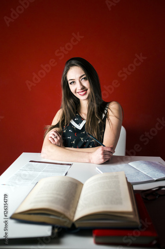 Young attractive brunette happy girl studying with book