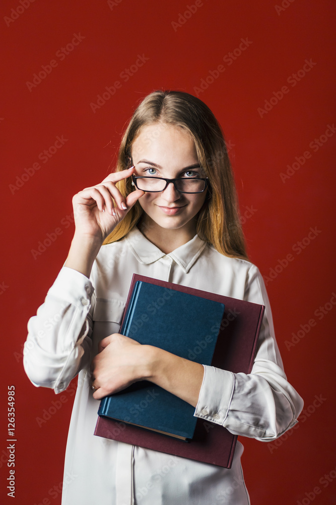 attractive happy smiling student blonde girl in white shirt with books on red background, student concept attractive happy smiling student blonde girl in white shirt with books on red background, student concept