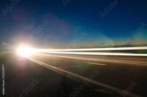 The asphalt road in the countryside with the light passing throu