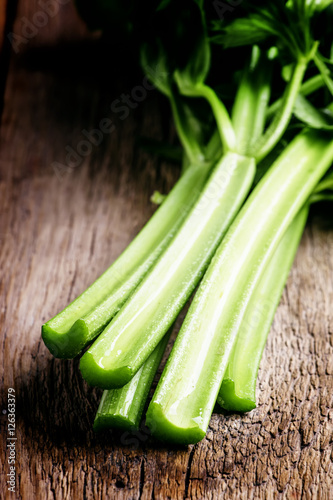 Stems of fresh celery with leaves on the table, vintage wooden b photo