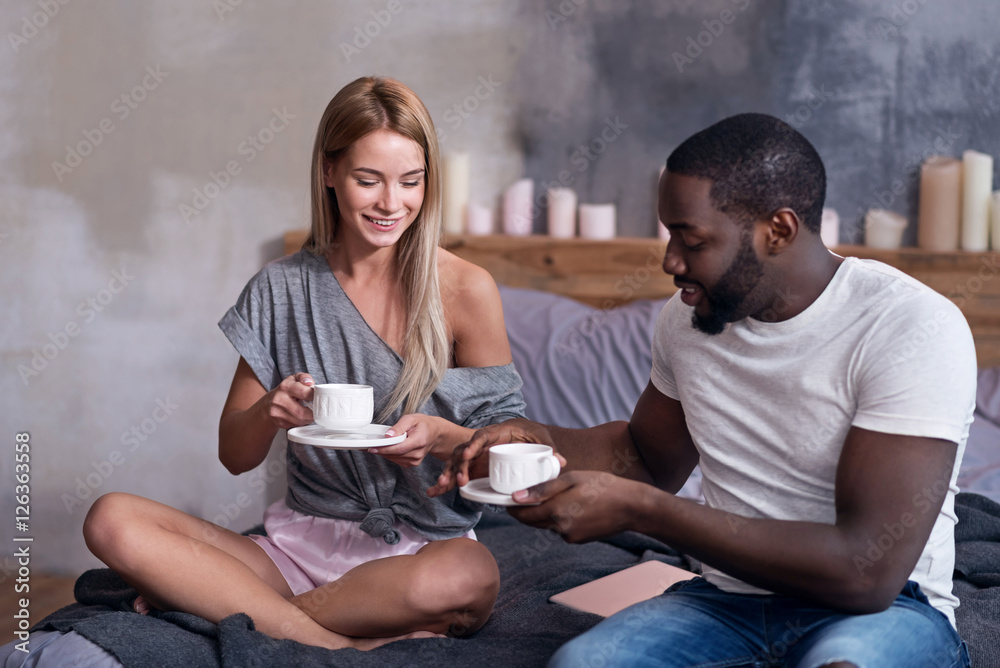 Cute couple having breakfast in bedroom together Cute couple having breakfast in bedroom together
