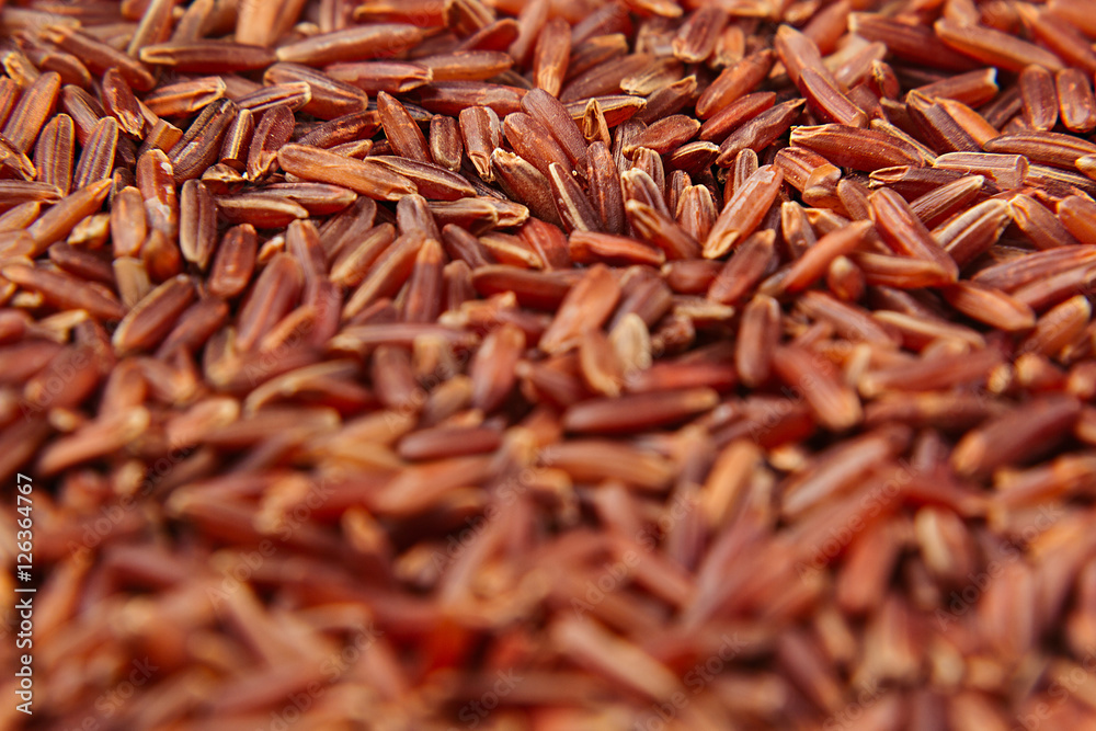 Red rice close-up background. Heap wild brown unpolished rice for vegetarians.