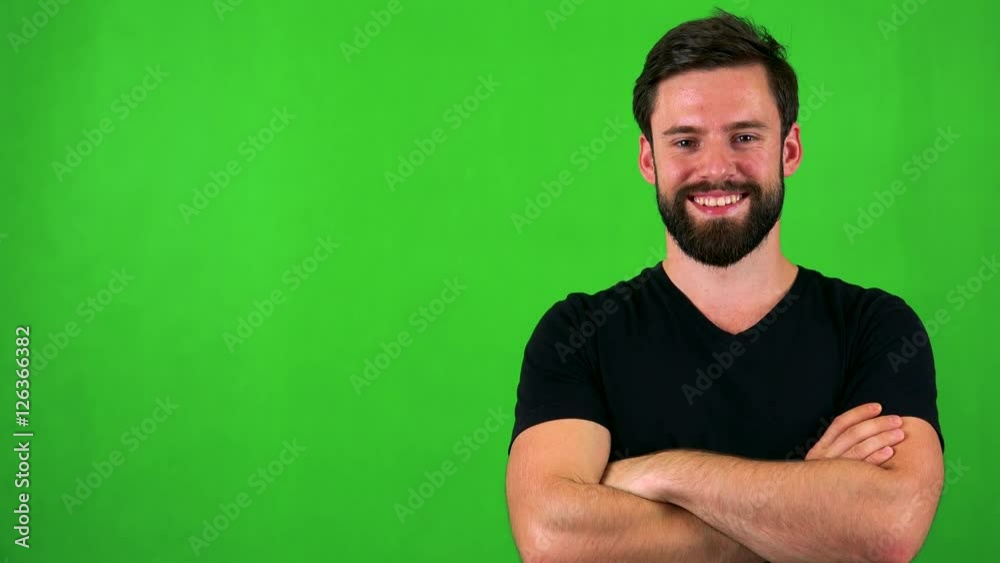 young handsome bearded man smiles to camera with folded arms - green screen young handsome bearded man smiles to camera with folded arms - green screen