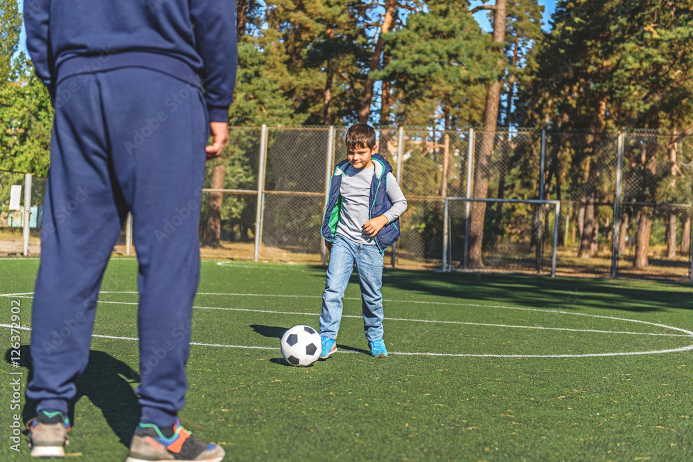 Obraz premium Man and son are playing football together