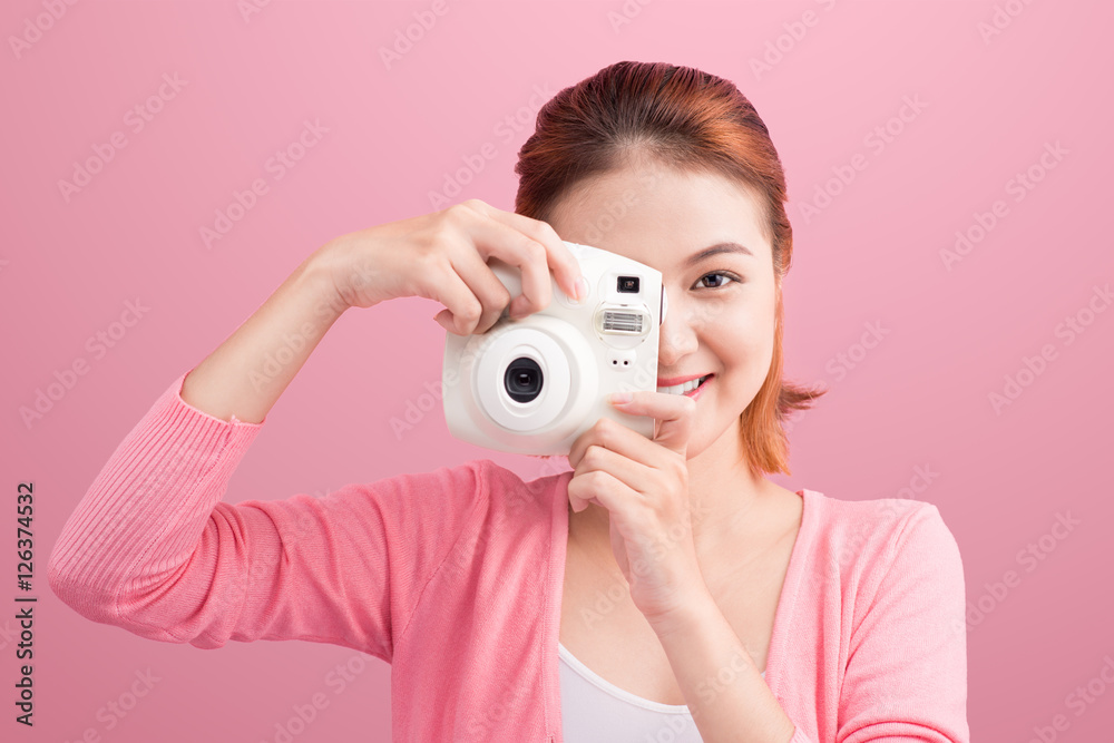 Fototapeta premium Young woman taking a photo with a camera.