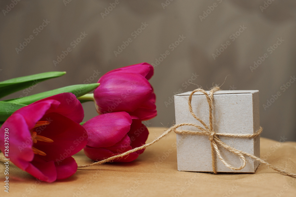 Purple tulip bouquet and gift box on wooden table with copy space Purple tulip bouquet and gift box on wooden table with copy space