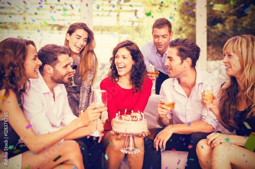 Composite image of cheerful woman celebrating her birthday with 