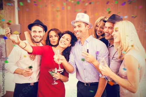 Composite image of cheerful woman taking selfie with friends
