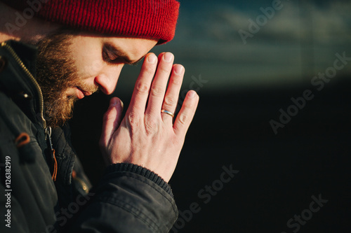 Man praying outside to God photo