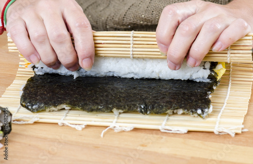 Woman making california roll, photo