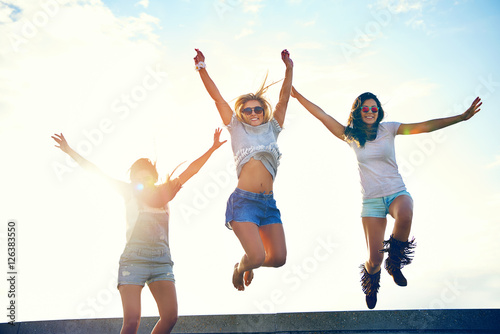 Three joyful young women leaping in the air