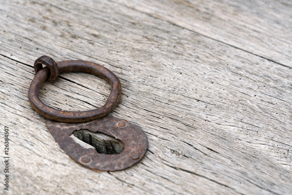 Old rusty iron ring and keyhole on a wooden background Old rusty iron ring and keyhole on a wooden background