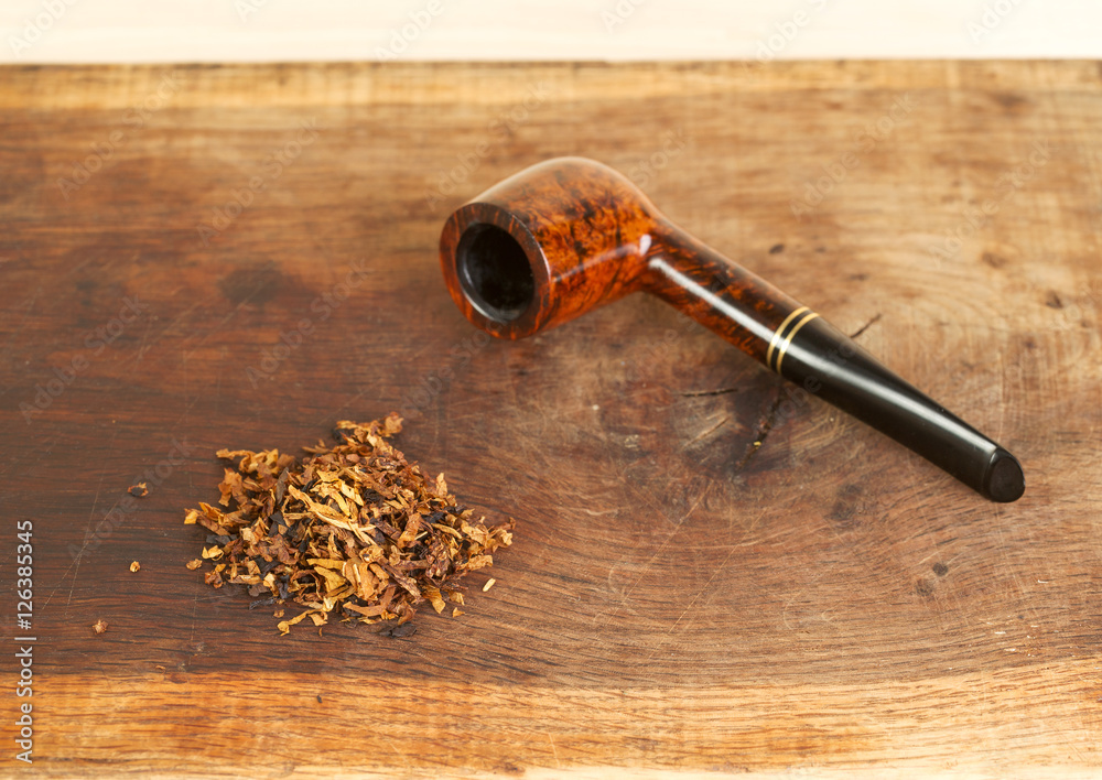 Smoking pipe on a wooden table. Aroma. Copy space. Top view