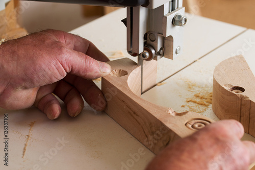 Carpenter tools on wooden table with sawdust. Band-saw to cut an intricate shape in a piece of wood.