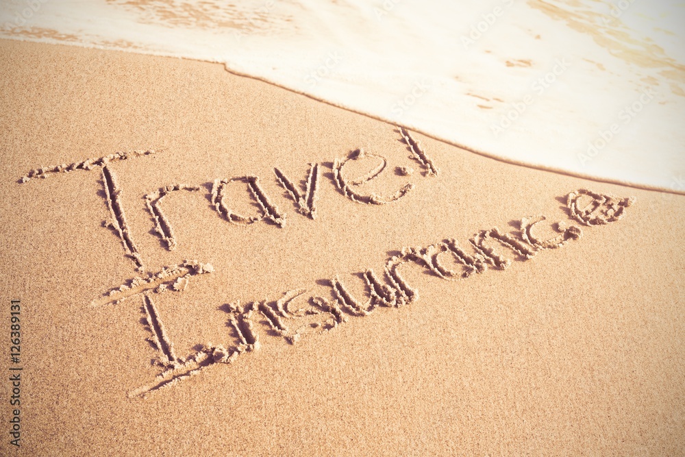 Travel Insurance text written on sand Travel Insurance text written on sand
