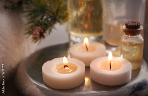 Candles with spa oil and Christmas decorations, closeup