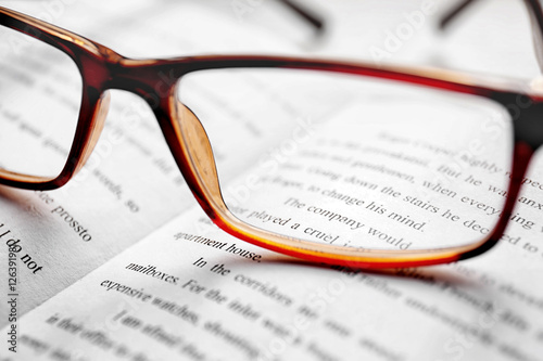 Glasses on open book, close up view. Healthy eyes concept