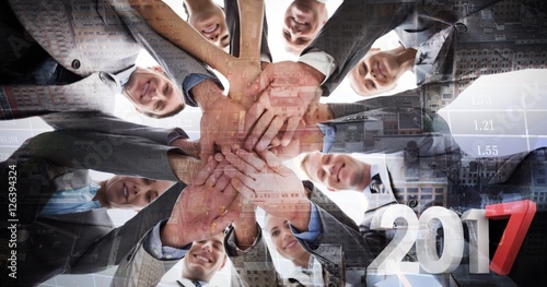 Composite image of smiling business team standing in circle hand