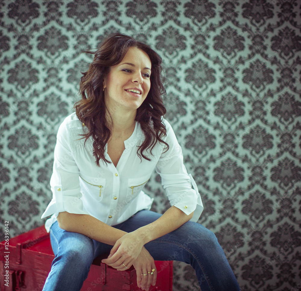 beautiful young woman in white shirt sits on red box beautiful young woman in white shirt sits on red box