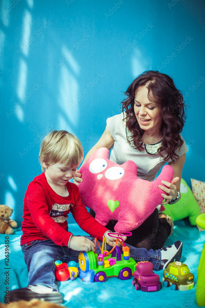 Naklejka premium little cute boy and his mother playing together
