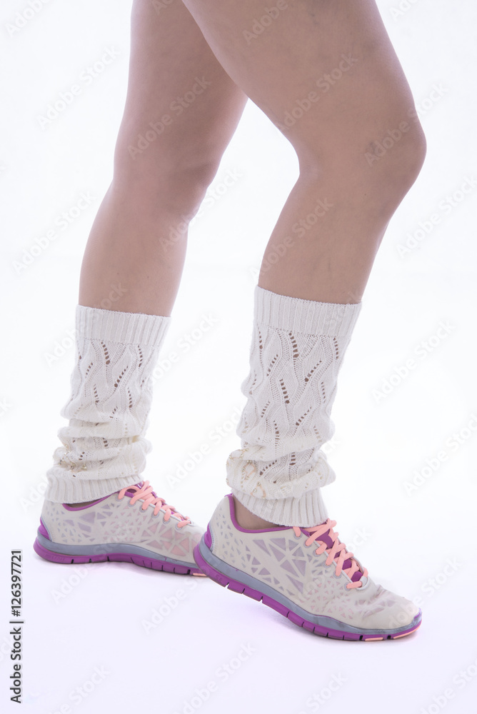 
gambe di donna con scalda muscoli e scarpe da tennis