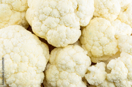 Raw cauliflower on a pile forming background