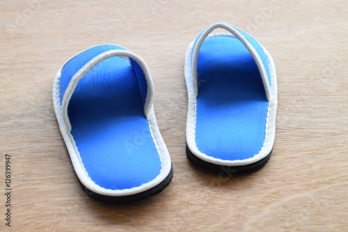Blue house slippers on wooden background