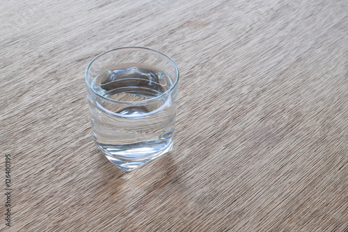 Glass of drinking water on wooden background