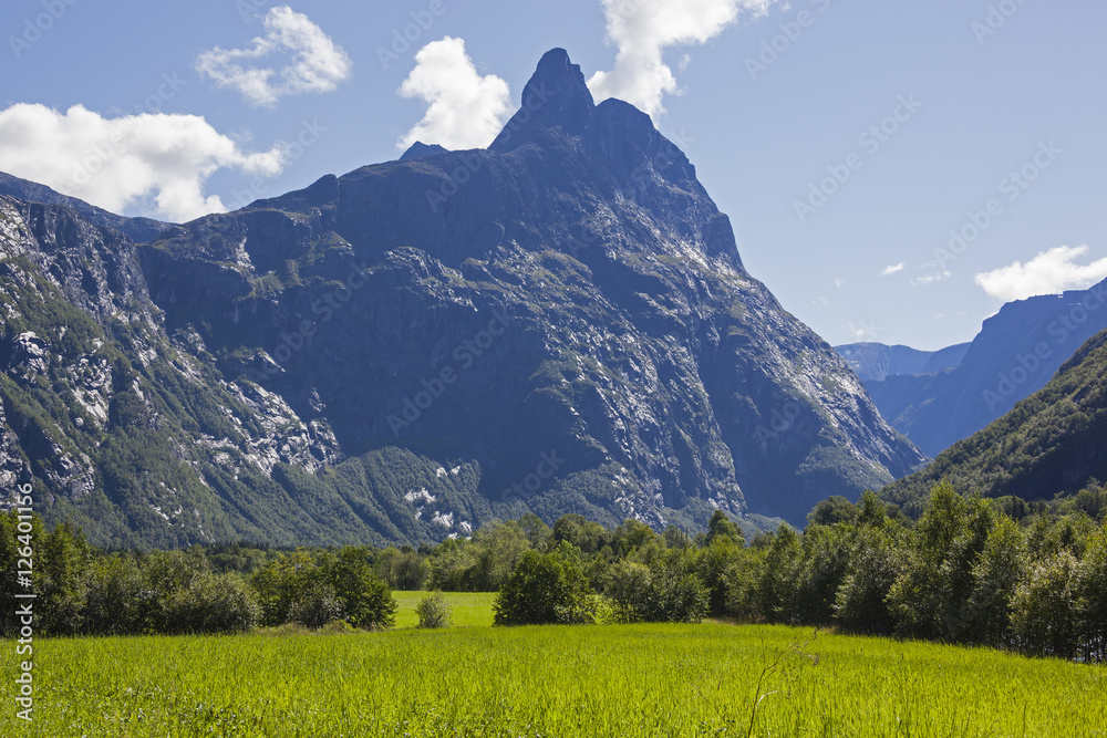 Obraz premium Green valley over the high cliffy peak, Troll wall massif, Norway