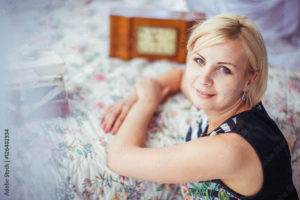 beautiful blonde woman sits on white blanket beautiful blonde woman sits on white blanket