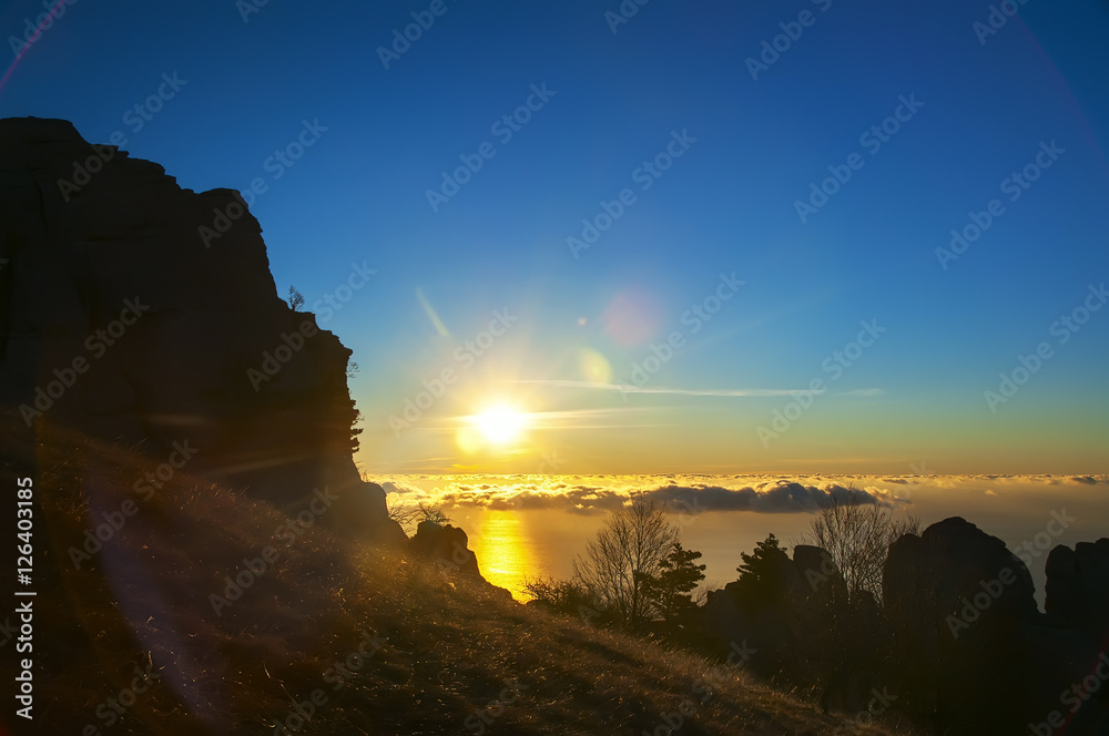 sunrise on the mountain. clouds View at the bottom and rises from the horizon of the sun.
