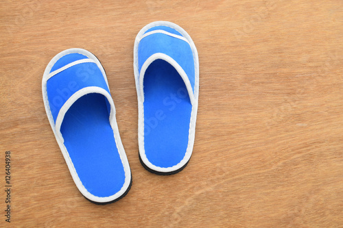 Blue house slippers on wooden background