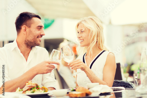 happy couple clinking glasses at restaurant lounge