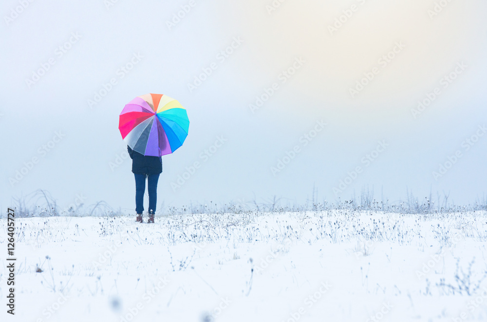 Young girl holding rainvbow umbrella - winter or christmas wallpaper