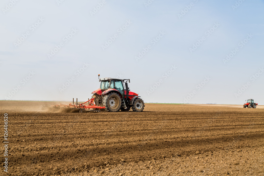 Farmer in tractor preparing land with seedbed cultivator Farmer in tractor preparing land with seedbed cultivator