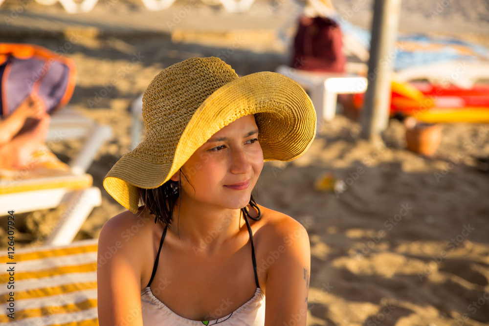 Smiling young woman wearing hat at the beach