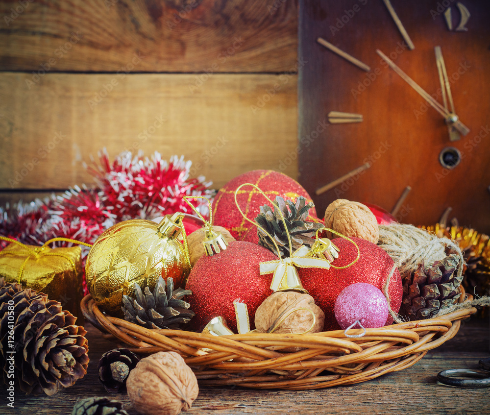 Christmas Composition red and yellow balls, cones,old clock in a basket on wooden background.Vintage style. toning Christmas Composition red and yellow balls, cones,old clock in a basket on wooden background.Vintage style. toning