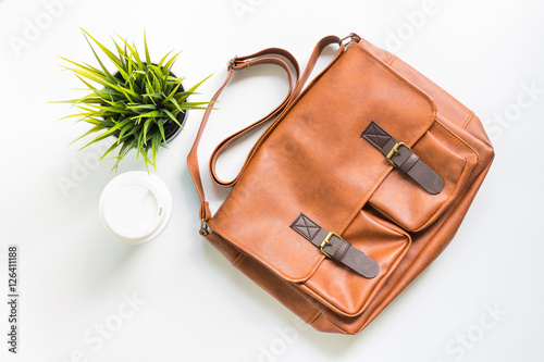 Men's fashion leather bag with tree decoration and coffee cup, flat lay, top view background