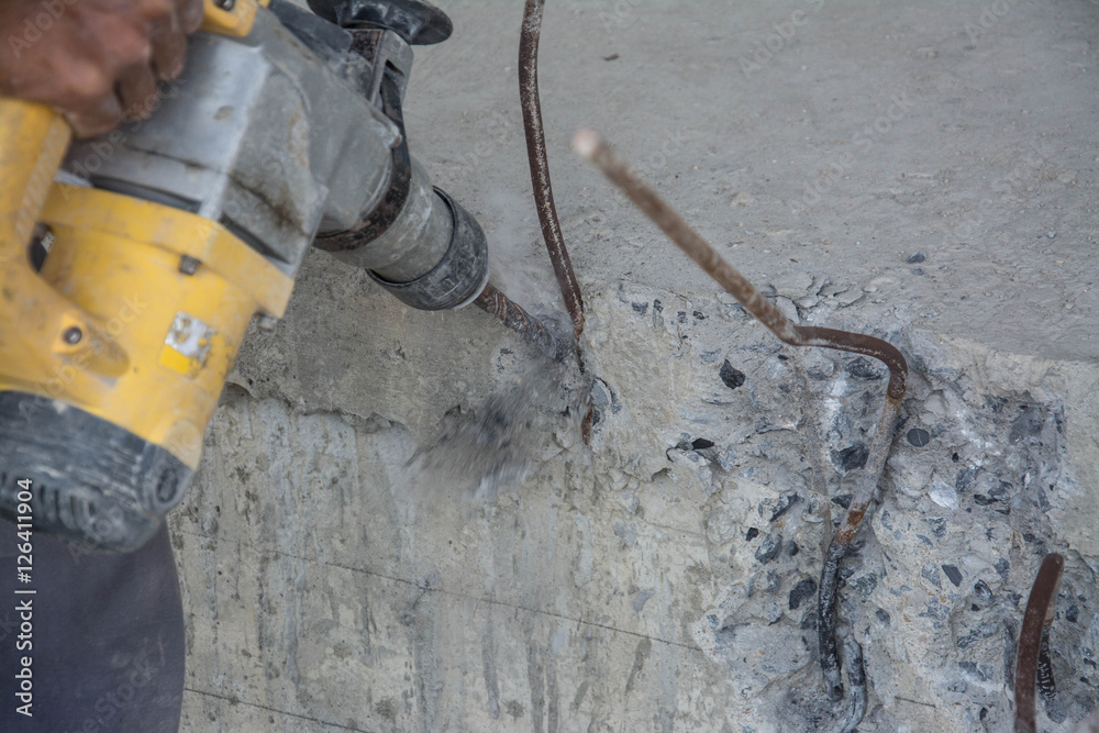 man use eectric drill to drill the concrete beam