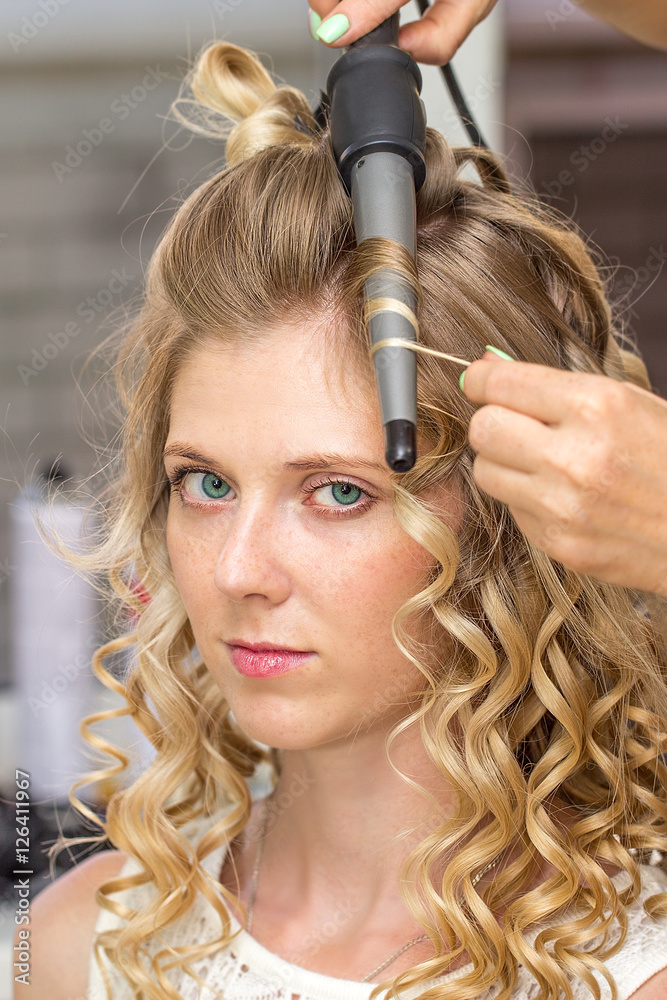 Fototapeta premium Hair stylist makes the bride before wedding