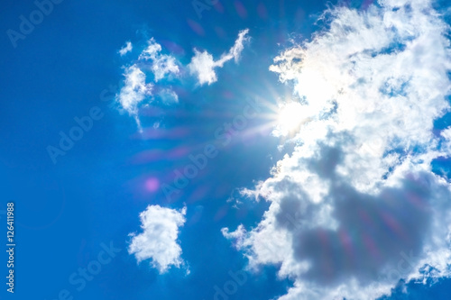 sun beam behind cloudy with blue sky nature background