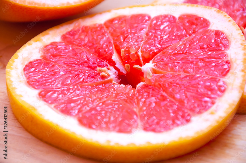 Sliced grapefruit on wooden cutting board. Fresh citrus close up Sliced grapefruit on wooden cutting board. Fresh citrus close up