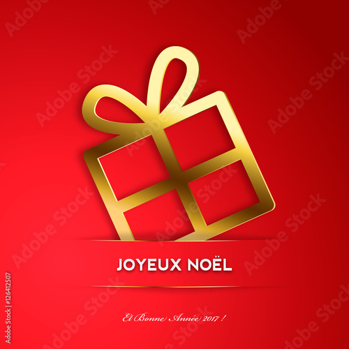 Cadeau de Noël doré derrière un ruban rouge