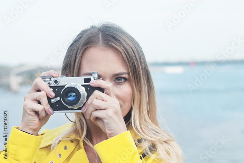 Portrait of a pretty tourist taking photographs with vintage ret © igorp17
