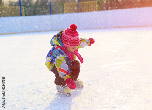 cute little girl learn to skate in winter