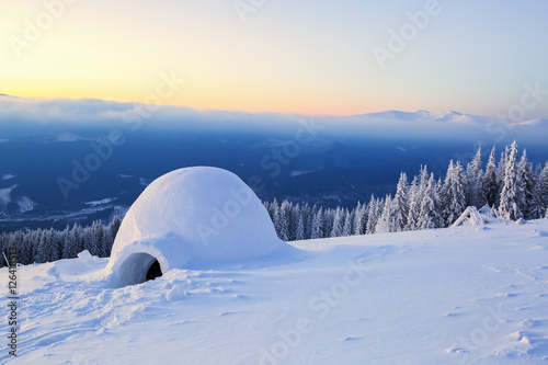 Big round igloo stands on mountains. © Vitalii_Mamchuk