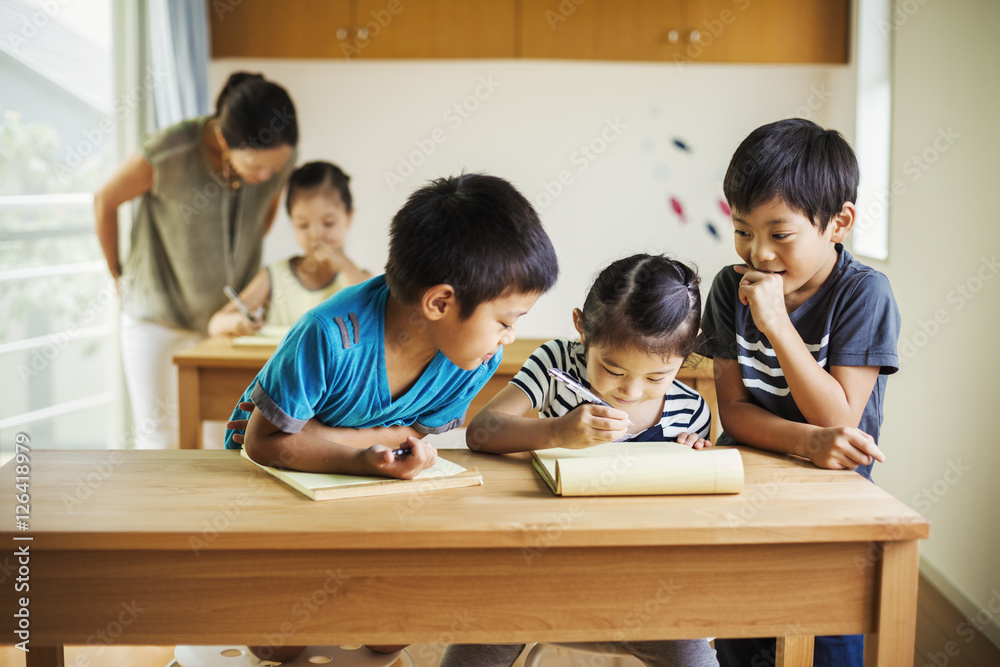Group of children in classroom with their female teacher Group of children in classroom with their female teacher