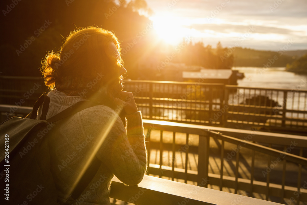 Sad girl looks at the sunset. A girl holding a backpack. Thoughtful ...