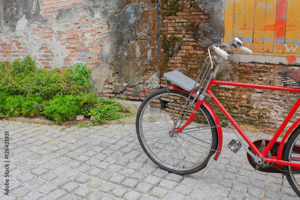 Vintage Red bicycle near the window of old brick wall 